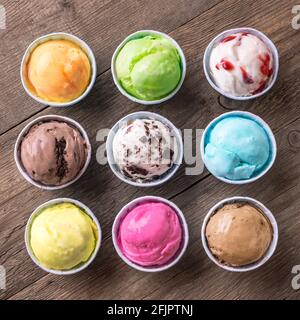 Eiscreme-Sortiment. Verschiedene Eiscreme oder italienisches Eis auf Holzhintergrund, Draufsicht. Gefrorener Joghurt in kleinen Tassen - gesundes Sommerdessert. Stockfoto