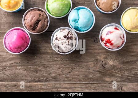 Eiscreme-Sortiment. Verschiedene Eiscreme oder italienisches Eis auf Holzhintergrund, Draufsicht, Kopierraum. Gefrorener Joghurt in kleinen Tassen - gesunder Sommer d Stockfoto
