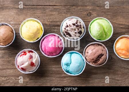 Eiscreme-Sortiment. Verschiedene Eiscreme oder italienisches Eis auf Holzhintergrund, Draufsicht. Gefrorener Joghurt in kleinen Tassen - gesundes Sommerdessert. Stockfoto