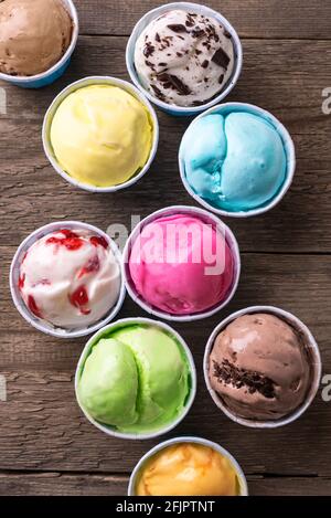 Eiscreme-Sortiment. Verschiedene Eiscreme oder italienisches Eis auf Holzhintergrund, Nahaufnahme. Gefrorener Joghurt in kleinen Tassen - gesundes Sommerdessert. Stockfoto