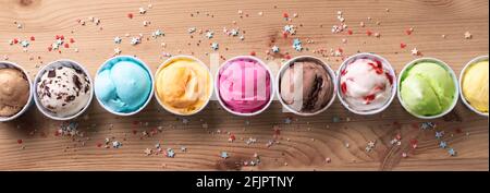 Eiscreme-Sortiment. Verschiedene Eiscreme oder italienisches Eis auf Holzhintergrund, Draufsicht, Banner. Gefrorener Joghurt in Tassen - gesundes Sommerdessert. Stockfoto