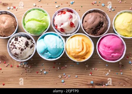 Eiscreme-Sortiment. Verschiedene Eiscreme oder italienisches Eis auf Holzhintergrund, Draufsicht. Gefrorener Joghurt in kleinen Tassen - gesundes Sommerdessert. Stockfoto