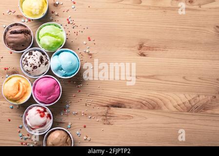 Eiscreme-Sortiment. Verschiedene Eiscreme oder italienisches Eis auf Holzhintergrund, Draufsicht, Kopierraum. Gefrorener Joghurt in kleinen Tassen - gesunder Sommer d Stockfoto