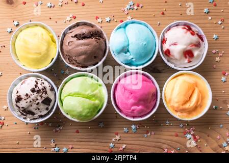 Eiscreme-Sortiment. Verschiedene Eiscreme oder italienisches Eis auf Holzhintergrund, Draufsicht. Gefrorener Joghurt in kleinen Tassen - gesundes Sommerdessert. Stockfoto