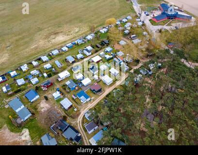 Pepelow, Deutschland. April 2021. Wohnwagen und Zelte von Dauercamper stehen auf dem Gelände des Ostseecamp 'am Salzhaff'. (Luftaufnahme mit Drohne) aufgrund der Corona-Schutzmaßnahmen sind die Campingplätze in Mecklenburg-Vorpommern derzeit geschlossen, auch Dauercamper dürfen nicht in ihren Wohnwagen oder Zelten übernachten. Quelle: Jens Büttner/dpa-Zentralbild/dpa/Alamy Live News Stockfoto