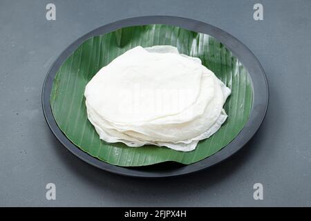 Schöne Pathiri südindischen malabar Spezialfutter aus Reis Mehl, das weiß ist rund dünn gebacken Essen traditionell angeordnet Auf schwarzem Teller gefüttert Stockfoto