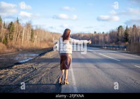 Das Mädchen hält das Auto mit der Hand auf der Autobahn an. Stockfoto