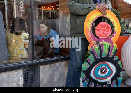 Columbus, Usa. April 2021. Black Lives Matter Aktivist steht vor einem Restaurant, in dem Menschen während eines Protestes gegen die Tötung von Ma'Khia Bryant durch die Polizei essen.Black Lives Matter Aktivisten versammelten sich mit einigen Familienmitgliedern von Ma'Khia Bryant im Goodale Park, um sich gegen die Brutalität der Polizei zu wehren. BLM-Aktivisten hörten den Rednern zu und besetzten dann stundenlang die Kreuzung von High Street und Bollinger Pl., während sie sich weiterhin gegen die Polizeibrutalität und die Polizeimorde von Ma'Khia Bryant aussprechen. Kredit: SOPA Images Limited/Alamy Live Nachrichten Stockfoto