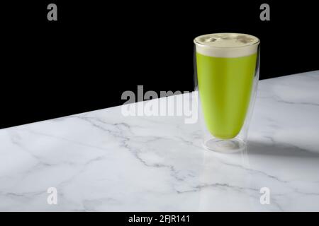 Cappuccino mit Matcha-Tee in Doppelwandglas Stockfoto
