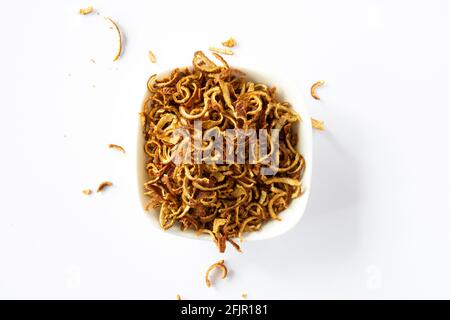 Geriebene und getrocknete Orangenschalen in einer Schüssel, auf weißem Hintergrund. Orangenschale mit selektivem Fokus. Stockfoto