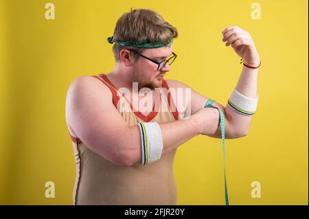 Ein Mann in Sportbekleidung misst sein Körpervolumen. Gesundes Lifestyle-Konzept, gesunde Ernährung Stockfoto