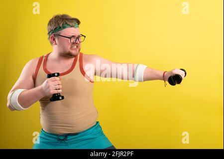 Fetter Mann mit schwarzen Shirt Training mit Hanteln und Kamera Stockfoto