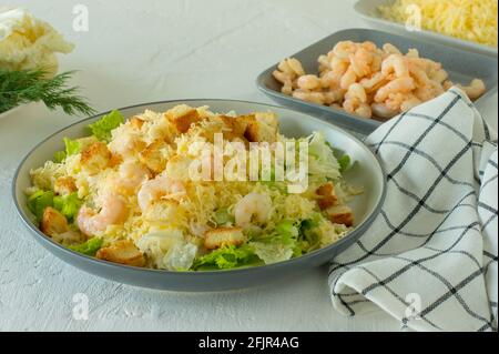 Hausgemachter Shrimp Caesar Salat mit Parmesa, Sauce und Croutons auf weißem Hintergrund. Stockfoto