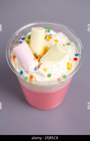 Rosafarbener Milchshake mit Moorlaibe in einem Plastikbecher. Stockfoto