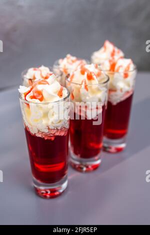 Drei rote alkoholische Cocktails mit Creme im Schuss Stockfoto