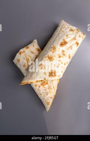 Appetitlich geschnittener Döner in Pita-Brot auf grauem Hintergrund. Stockfoto