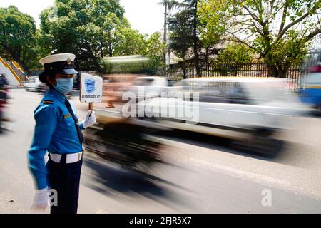 Kathmandu, Nepal. April 2021. Eine Verkehrspolizei zeigt Pendlern ein Sicherheitsschild, da sie besorgt ist über die Ausbreitung der zweiten Welle der Coronavirus-Krankheit in Kathmandu, Nepal, am Montag, dem 26. April 2021. Kredit: Skanda Gautam/ZUMA Wire/Alamy Live Nachrichten Stockfoto