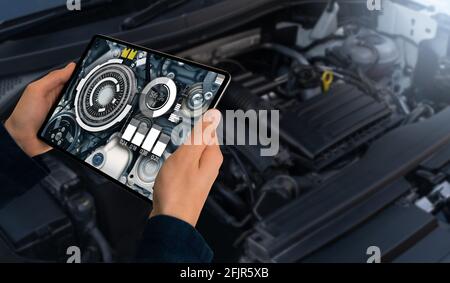 Servicemanter reparieren ein Auto mit der Anwendung "Augmented Reality". Stockfoto