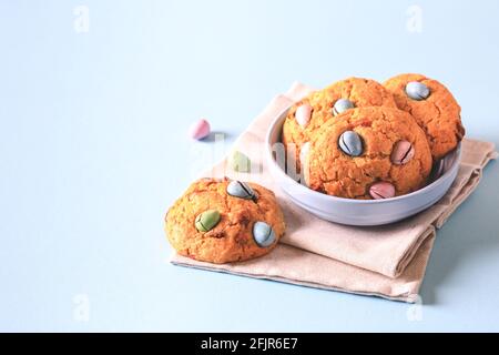 Hausgemachte Kekse Schokoladenchips mit bunten Süßigkeiten Eier auf blauem Hintergrund. Stockfoto