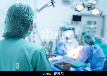 Assistent oder Mitarbeiter des Team-Chirurgen bei der Arbeit im Operationssaal. Stockfoto