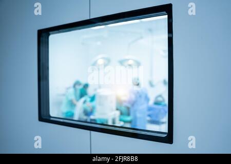 Verschwommen durch das Türglas der Chirurgen im Operationssaal. Stockfoto