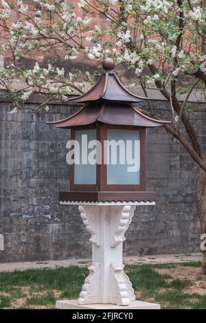 Lampe mit roter Wand und Frühlingsblumen in der Verbotenen Stadt, Peking, China Stockfoto