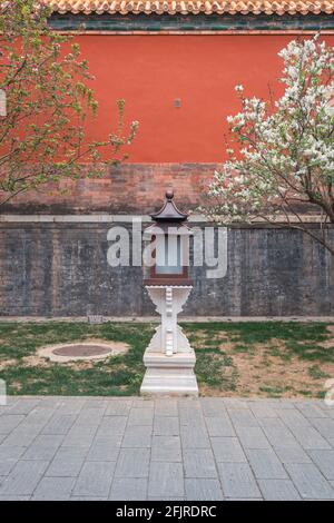 Lampe mit roter Wand und Frühlingsblumen in der Verbotenen Stadt, Peking, China Stockfoto