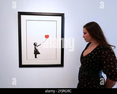 Girl with Balloon ist eine 2002 gestartete Londoner Serie von Schablonen-Wandmalereien der Graffiti-Künstlerin Banksy, die ein junges Mädchen zeigt, dessen Hand auf einen roten, herzförmigen Ballon gerichtet ist, der vom Wind weggetragen wird. Stockfoto