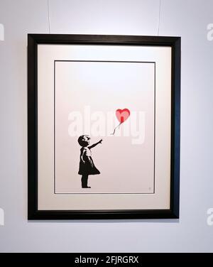 Girl with Balloon ist eine 2002 gestartete Londoner Serie von Schablonen-Wandmalereien der Graffiti-Künstlerin Banksy, die ein junges Mädchen zeigt, dessen Hand auf einen roten, herzförmigen Ballon gerichtet ist, der vom Wind weggetragen wird. Stockfoto