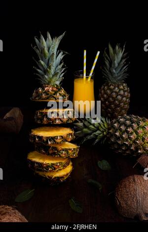 Ananas fliegend in der Luft, in Scheiben mit Saft geschnitten Glas und Ananas im Hintergrund Stockfoto