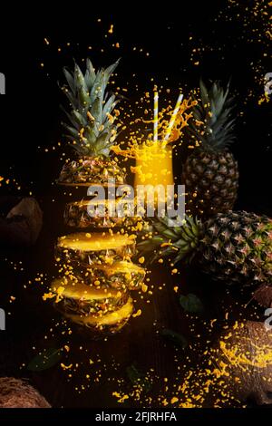 Ananas fliegend in der Luft, in Scheiben geschnitten mit Saftspritzern Stockfoto