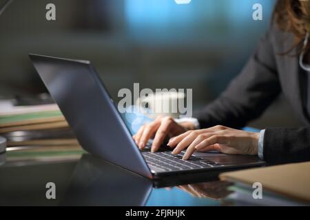 Nahaufnahme eines Telearbeiters mit der Hand auf dem Laptop Nachts im Homeoffice Stockfoto