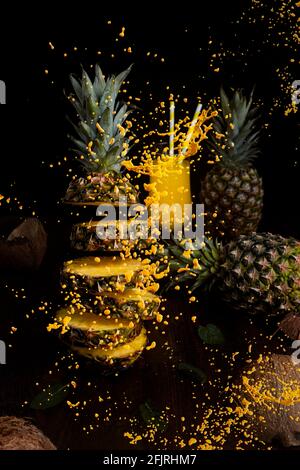 Ananas fliegend in der Luft, in Scheiben geschnitten mit Saftspritzern Stockfoto