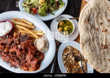 Alanya, Türkei. 8. April 2021 Teller Iskender oder Bursa Kebab mit türkischem Mezze und traditionellem Brot. Typische lokale Küche in der Türkei Stockfoto