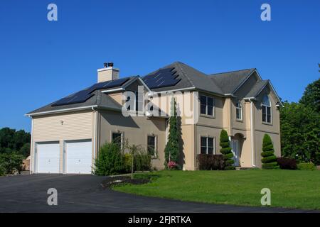 MIDDLETOWN, NY, VEREINIGTE STAATEN - Jul 14, 2020: Suburban Solar Pannel Home zweistöckiges großes Haus. Immobilien-Haus mit Solarpanels auf dem Dach, grün hom Stockfoto