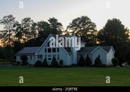 MIDDLETOWN, NY, VEREINIGTE STAATEN - Jul 14, 2020: Vorstadt Solar Pannel Home mit großen Yard Bäume bei Sonnenuntergang, Immobilien-Haus mit Solar Pannels auf dem Dach Stockfoto