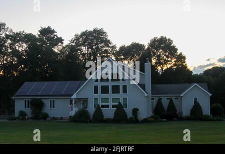 MIDDLETOWN, NY, VEREINIGTE STAATEN - Jul 14, 2020: Vorstadt Solar Pannel Home mit großen Yard Bäume bei Sonnenuntergang, Immobilien-Haus mit Solar Pannels auf dem Dach Stockfoto