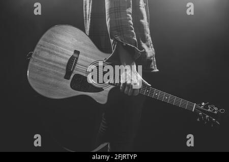 Ein Mann, der eine akustische Gitarre in den Händen hält. Stockfoto