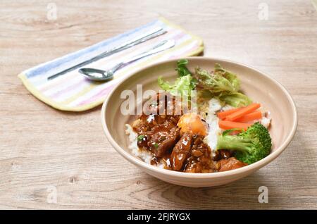 Gebratenes Hähnchendressing Teriyaki japanische Sauce auf Reis mit gekochtem Ei und Gemüse in einer Schüssel Stockfoto