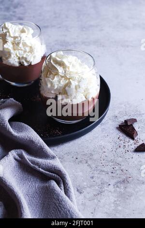 Zwei Tassen Liegeois-Schokoladenpudding mit Schlagsahne. Stockfoto