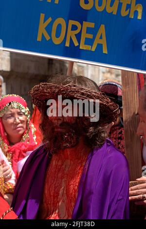 Israel, Jerusalem die Via Dolorosa Prozession, Karfreitag, Ostern 2007 südkoreanische Pilger Re enacting Jesus mit Blut bedeckt, trägt das Kreuz auf Stockfoto