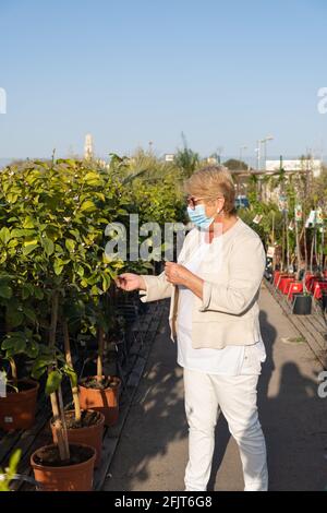 Frau, die in einem Pflanzenladen im Freien einkauft. Stockfoto