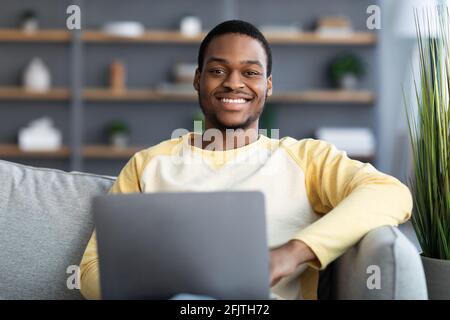 Nahaufnahme von fröhlichen schwarzen Kerl mit Laptop Stockfoto