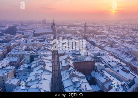 Krakauer Altstadt im Winter. Schnee auf Dächern in der Altstadt im Winter Krakau Polen bei Sonnenuntergang. Historischer Hauptstadtplatz Rynek, Royal Road und Kirchen. Stockfoto