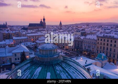 Schneebedeckter Winter in Krakau Polen Luftaufnahme. Altstadt, Dach des Juliusz Slopacki-Theaters und Rynek Glowny mit Marienbasilika und Stadt Stockfoto