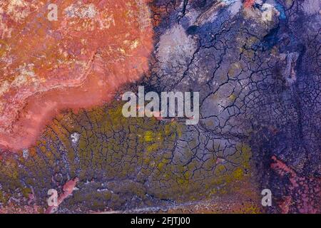 Luftdrohnenaufnahme der Müllhalde für Industriechemikalien, trockener mehrfarbiger Boden, einzigartige Textur. Stockfoto