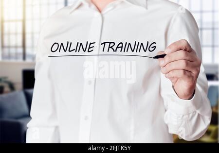 Businessman Hand hält einen Stift und unterstreicht die Worte Online-Training auf einem virtuellen Bildschirm. Online-Fernschulungskonzept. Stockfoto