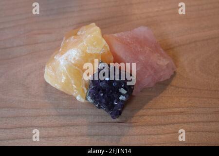 Ein Trio aus Rosenquarz, goldenen Calcit- und Amethyst-Steinen Stockfoto