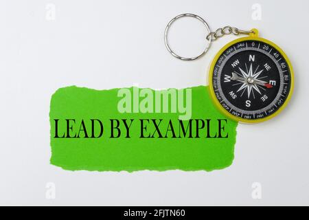 Führen Sie durch ein Beispiel auf einem grünen zerrissenen Papier mit Kompass geschrieben. Stockfoto