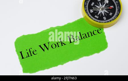 Life Work Balance auf einem grünen zerrissenen Papier mit Kompass geschrieben. Stockfoto
